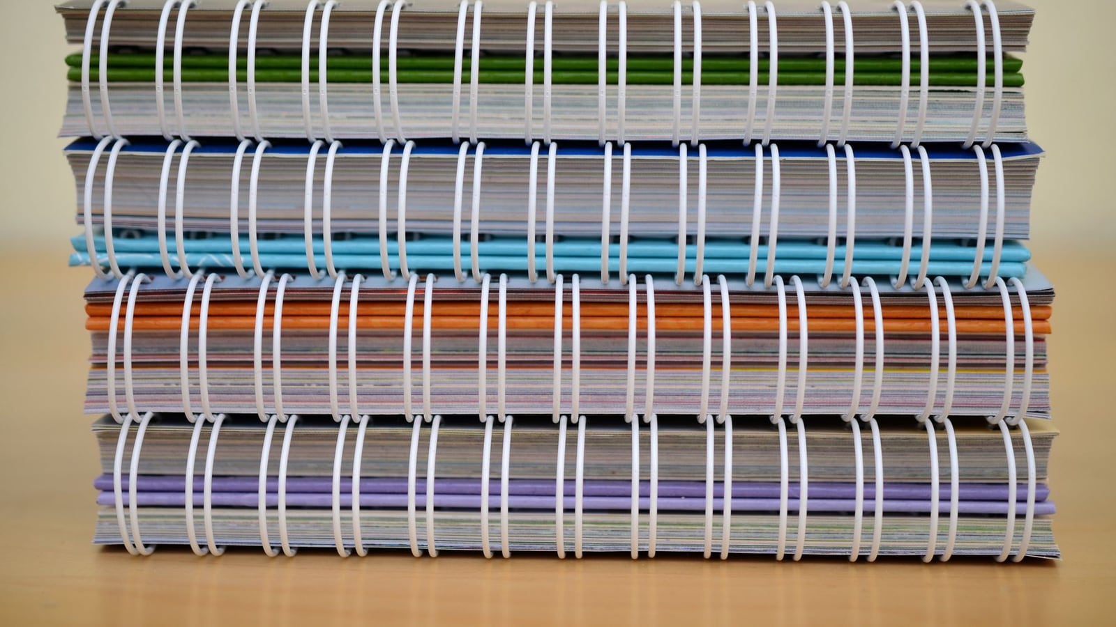 Comparison of different binding styles: stitching, hardcover, and leather binding on a workbench.