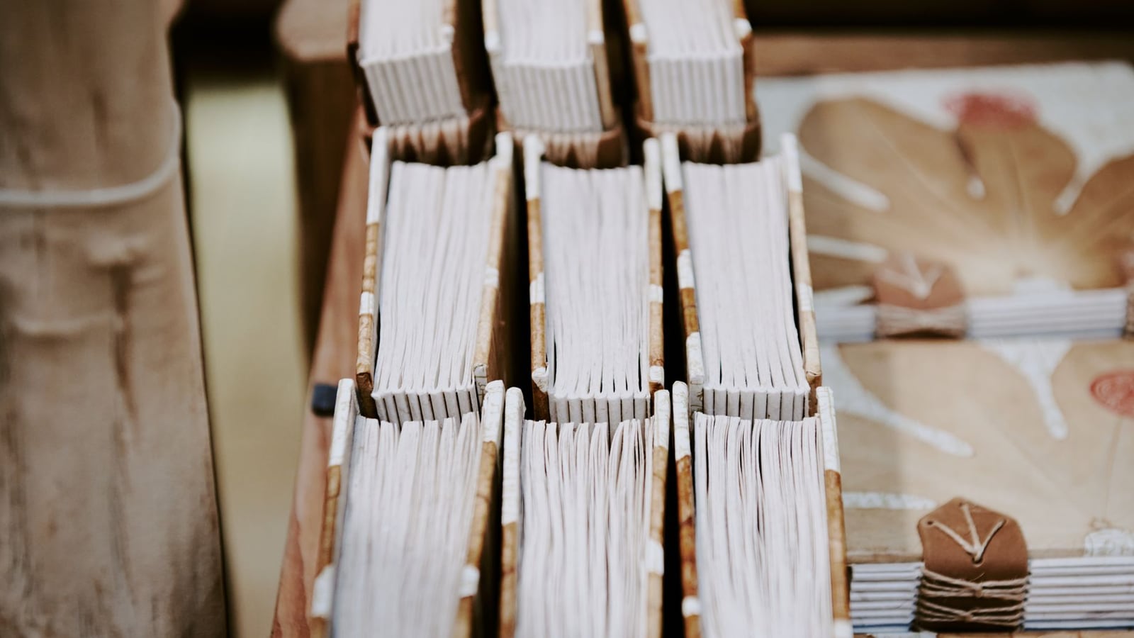 A sunlit traditional bookbinding studio in Linz featuring leather hides and binding presses.